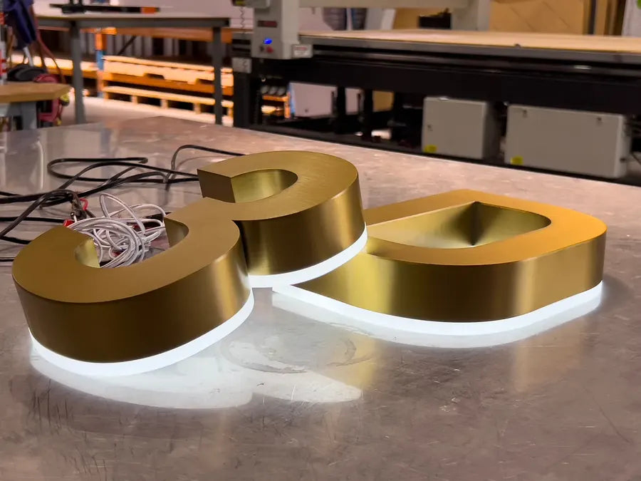 Halo-lit metal sign mounted on a wall