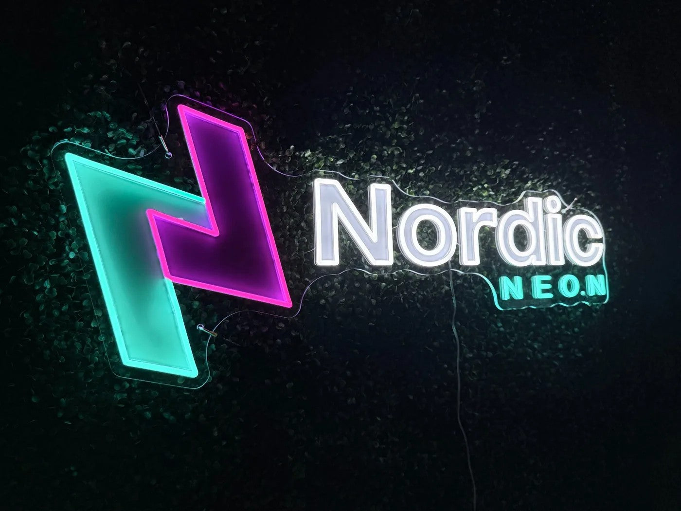 Nordic Neon logo sign on a plant wall