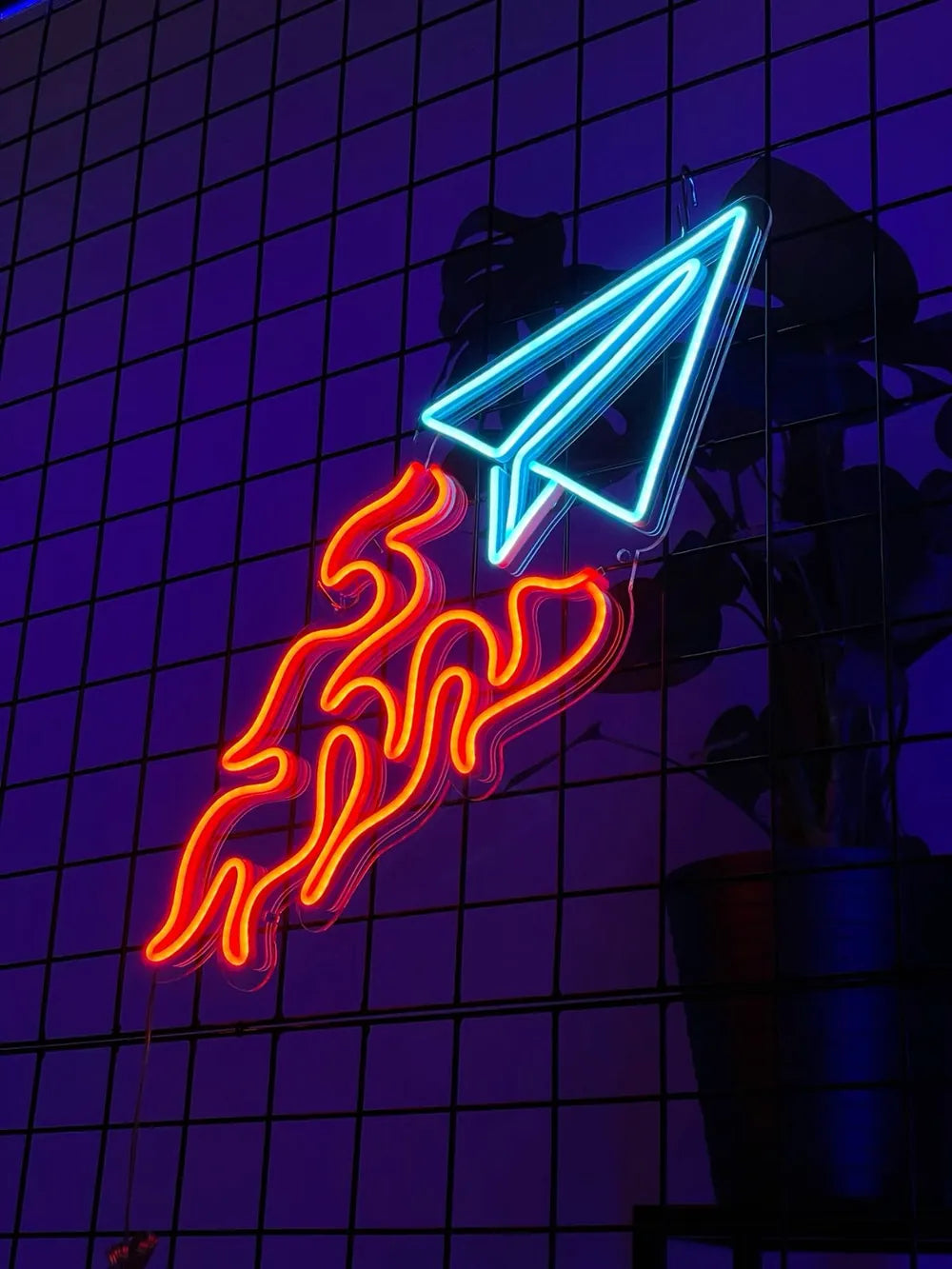 Neon sign shaped like a paper plane with flames